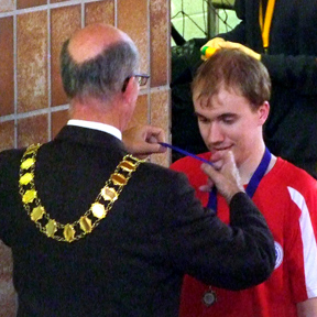 Cllr Roderick Hogarth, Mayor of Sevenoaks Town Council presents Oliver with his Senior Relay silver medal